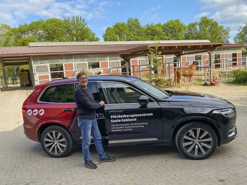HN Vets Fahrzeugbeklebung an einem schwarzen SUV vor Stallanlage mit Pferd im Hintergrund