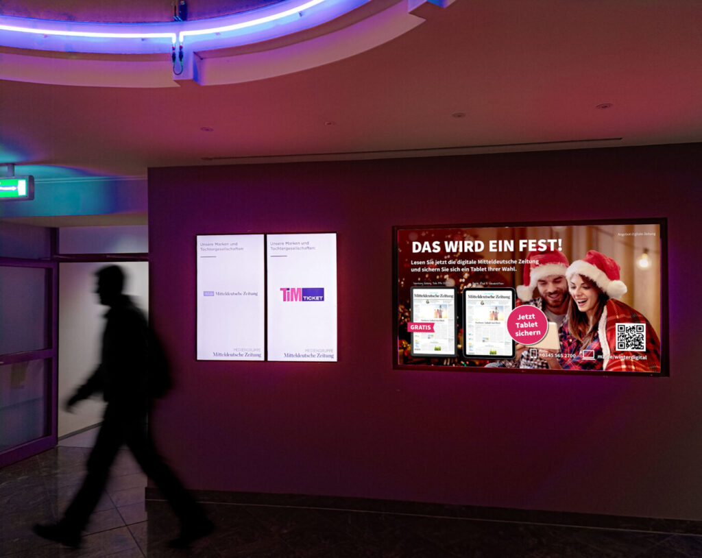 Digital‑Signage‑Motiv der Aboaktion Weihnachten 2025 mit festlichem Angebotslayout auf Großbildschirm in Innenraum